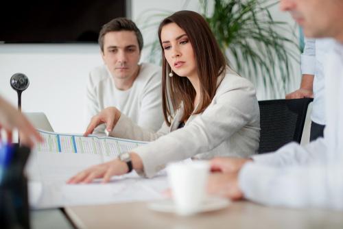 Woman on a meeting holding chart and analyzing