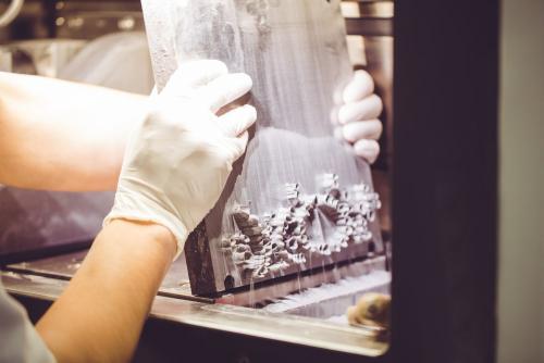 Dental technician using 3D printer to produce denture